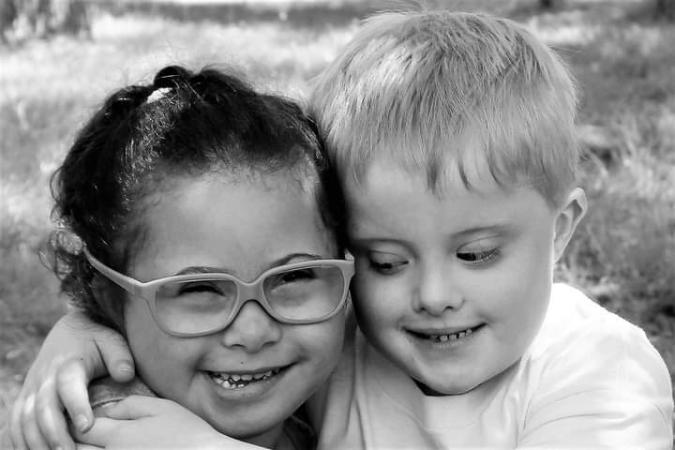 Two smiling children embrace