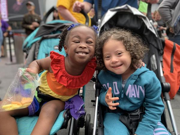 toddlers with Down syndrome hugging and smiling at the camera